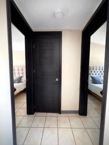 a black door in a room with two beds at Casa-Alojamiento Tierra roja in Arandas