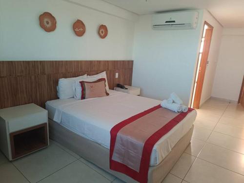 Un dormitorio con una cama grande y una mesa. en Flat em Palmas Vivence Suítes, en Palmas