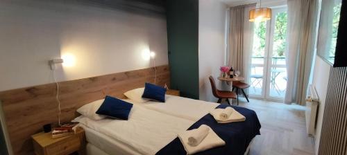 a bedroom with two beds with blue and white pillows at Cicha Przystań - Pokoje Przy Latarni in Kołobrzeg