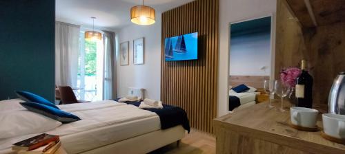 a bedroom with a bed and a desk and a room with at Cicha Przystań - Pokoje Przy Latarni in Kołobrzeg