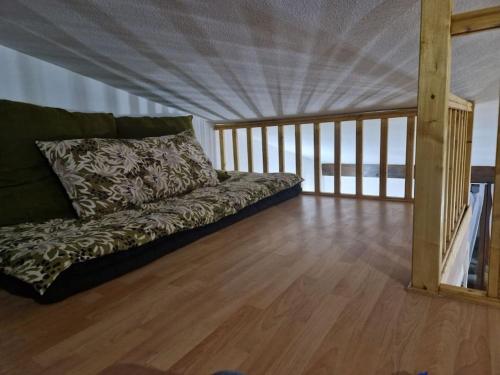 - un canapé dans une chambre dotée de parquet dans l'établissement Appartement à 25 min de la plage, à Tourbes