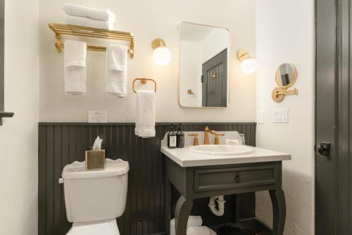 a bathroom with a sink and a toilet and a mirror at Petit Soleil - Bed, Breakfast and Bar in San Luis Obispo