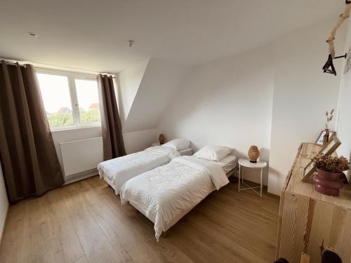 deux lits dans une chambre blanche avec une fenêtre dans l'établissement BonAir s House La Maison du Bon Air, à Wimereux
