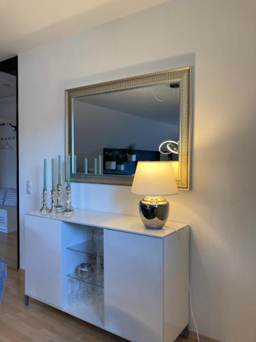 a table with a lamp and a mirror on a wall at Ferienwohnung Finkenschlag in Speyer