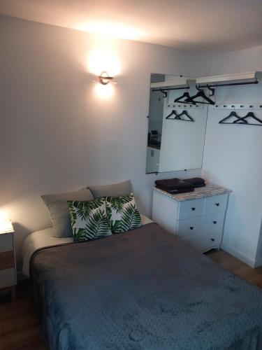 une chambre avec un lit, une commode et un miroir dans l'établissement Cosy Paris, à Paris