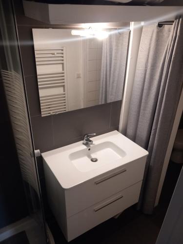 une salle de bain avec un lavabo blanc et un miroir dans l'établissement Cosy Paris, à Paris
