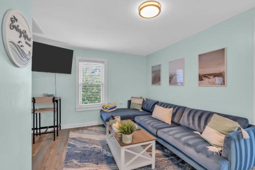 a living room with a blue couch and a table at 6-Min Walk to Asbury Park & OG Main St - Updated & Cozy Apartment in Historic Ocean Grove - Fire Pit & Patio - Fast Wi-Fi in Ocean Grove