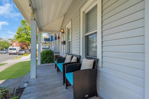 a porch with wicker chairs on a house at 6-Min Walk to Asbury Park & OG Main St - Updated & Cozy Apartment in Historic Ocean Grove - Fire Pit & Patio - Fast Wi-Fi in Ocean Grove