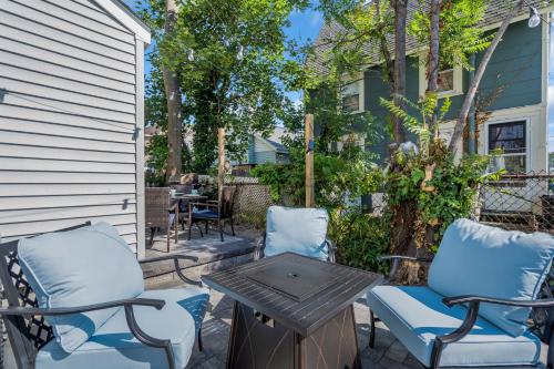 a patio with two chairs and a table at 6-Min Walk to Asbury Park & OG Main St - Updated & Cozy Apartment in Historic Ocean Grove - Fire Pit & Patio - Fast Wi-Fi in Ocean Grove