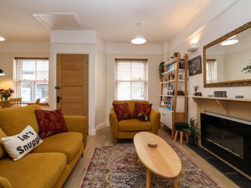 a living room with a couch and chairs and a fireplace at Hardings cottage in Minehead