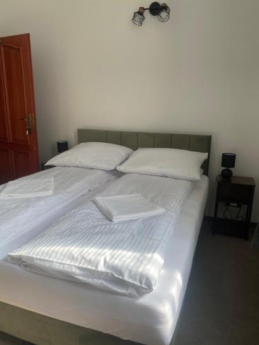 a large white bed with white sheets and pillows at Zamek Nowęcin in Łeba