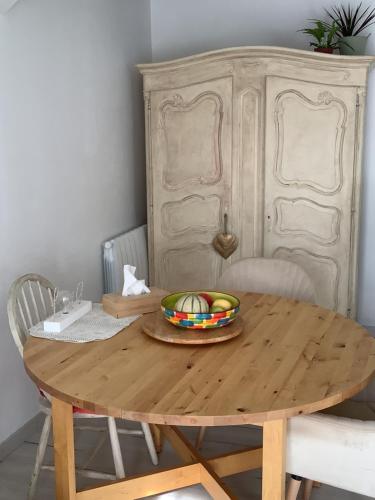 a wooden table with a bowl of fruit on it at Rdc de ma maison dans un joli village Provençal, 15 mins d'Aix en Pce, open space joliment rénové in Fuveau