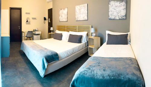 a bedroom with two beds and a desk at Hotel Ristorante Centosedici in Terracina
