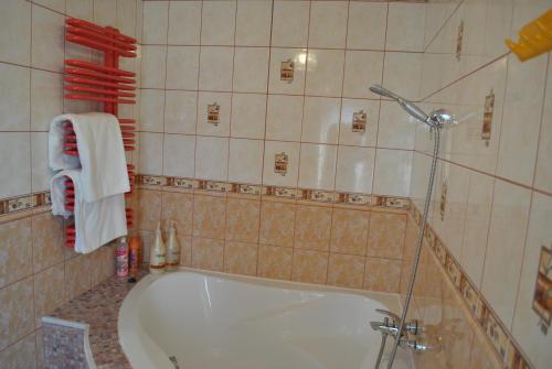 a bathroom with a tub and a shower with towels at Flamingo in Poręba Żegoty