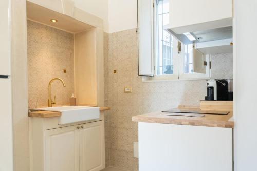 una cucina bianca con lavandino e finestra di Apollo & Artemide Suite a Siracusa