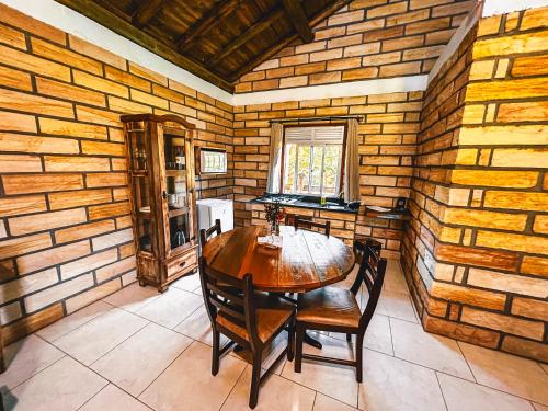 a dining room with a wooden table and chairs at Pousada Equilíbrio dos Canyons in Praia Grande