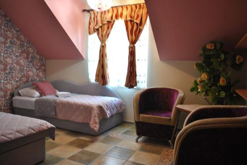 a bedroom with a bed and a chair and a window at Flamingo in Poręba Żegoty
