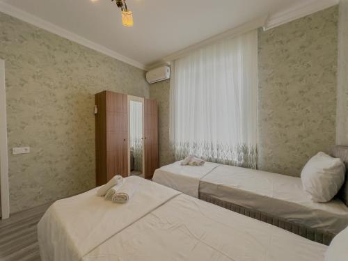 a hotel room with two beds and a window at Qafqaz Magnolia Harmony in Gabala