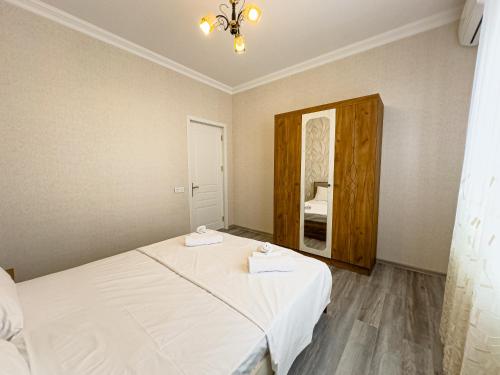 a small bedroom with a bed and a mirror at Qafqaz Magnolia Harmony in Gabala