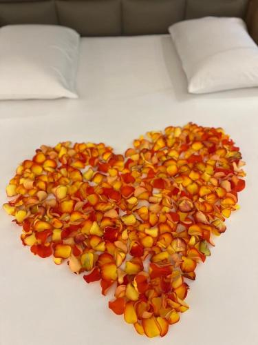 a pile of fruit in the shape of a heart on a bed at Status Motel Ourinhos in Ourinhos