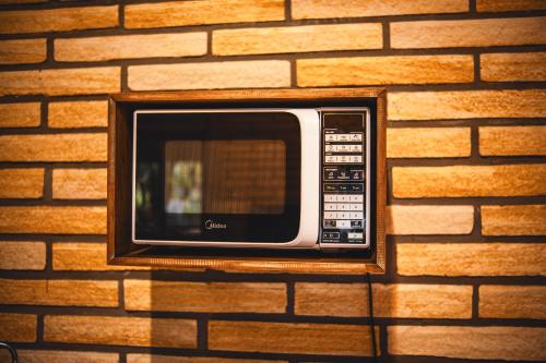 a microwave is attached to a brick wall at Pousada Equilíbrio dos Canyons in Praia Grande