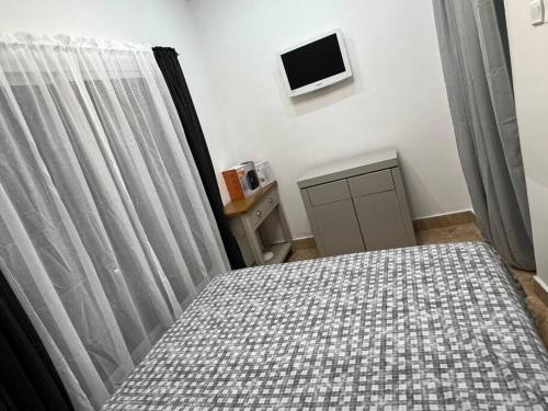 a bedroom with a bed and a tv on the wall at Apartment Complex bijilo The gambia in Bijilo