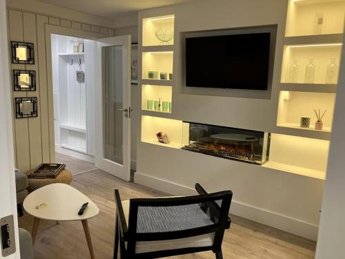 a living room with a tv and a chair and a table at Luxury Town Centre Apartment in Killorglin