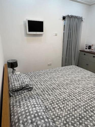 a bedroom with a bed and a tv on the wall at Apartment Complex bijilo The gambia in Bijilo