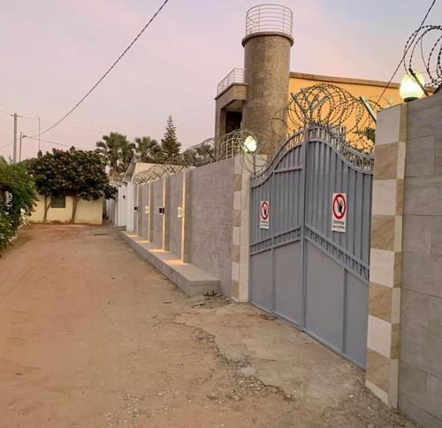 a fence with a gate in front of a building at Apartment Complex bijilo The gambia in Bijilo