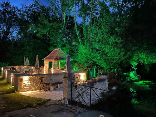 a backyard with a bench and a gazebo at night at Moulin la vergne in Champagne-et-Fontaine