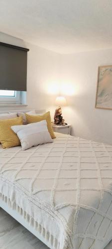 a large white bed in a room with a lamp at Apartment BoNo in Šmrika