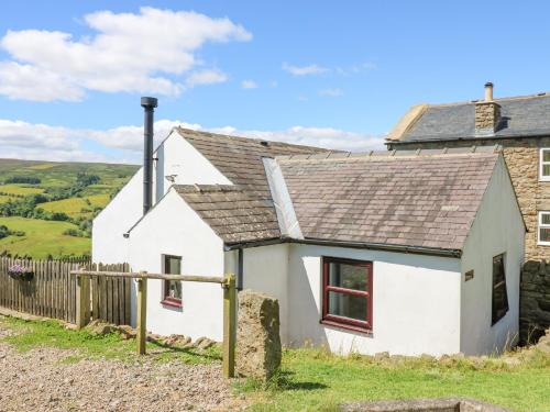 a white cottage with a slate roof at Dale View Cottage in Hexham