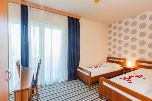 カシュテラにあるairport rooms Manufakturaのベッドが2つと窓があるホテルの部屋