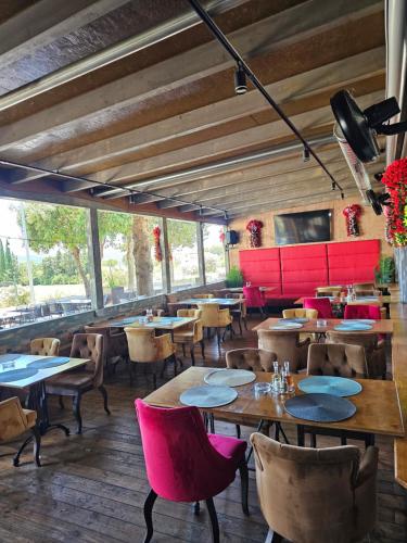 カシュテラにあるairport rooms Manufakturaのテーブル、椅子、赤い椅子が備わるレストラン