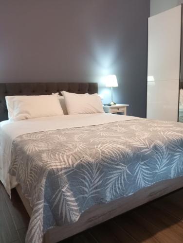 a bedroom with a large bed with a blue and white blanket at Peti's Apartment in Prinos