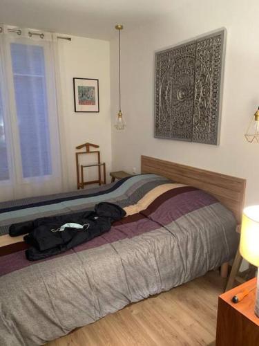 - une chambre dotée d'un lit avec une pile de vêtements dans l'établissement Appartement chic à Colombes, à Colombes