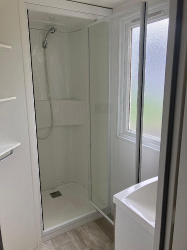 une salle de bain blanche avec une douche et un lavabo dans l'établissement Mobilhome 6 personnes, dans camping 4 étoiles, Argeles sur mer, à Argelès-sur-Mer