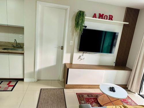a living room with a tv on a wall at Apartamento Decorado na Serra em Itaipava in Petrópolis