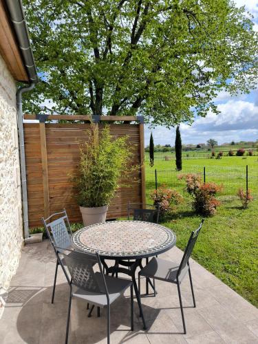 a table and chairs sitting on a patio at Maison de caractère près de Bergerac in Saint-Laurent-des-Vignes