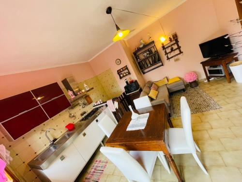 a kitchen and living room with a table and chairs at Villetta a schiera indipendente in Castagneto Carducci