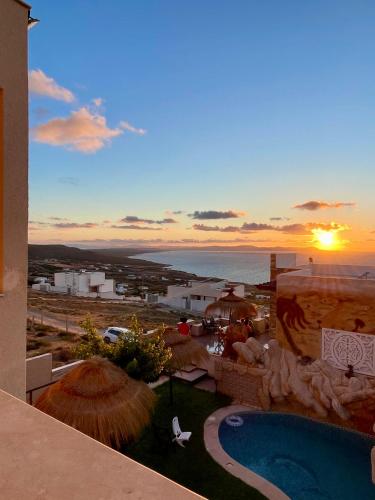 a view of a resort with a swimming pool and the ocean at Master Suite in Bellavista Andalucia with Pool and Beach in Al Matlīn