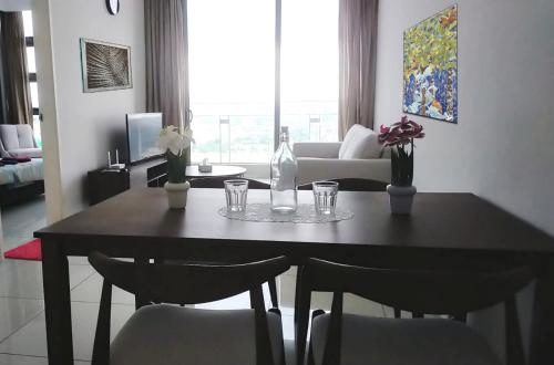 a dining room table with chairs and a bottle and glasses at Pool Haven Reservations in Kuala Lumpur
