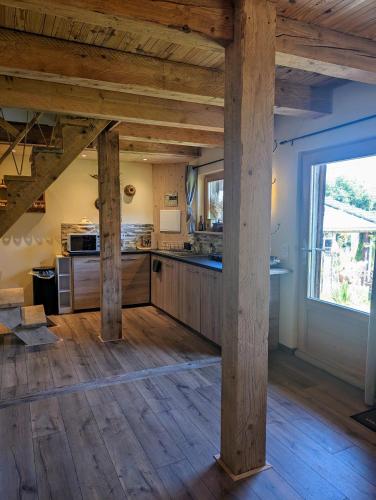 a large kitchen with wooden floors and a large window at La grange de la petite souris in Bouxwiller