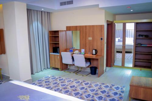 a room with a desk and two white chairs at Jees Hotel in Hargeysa