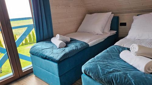 a couple of beds in a room with a window at Domki U Sieronia in Mielenko