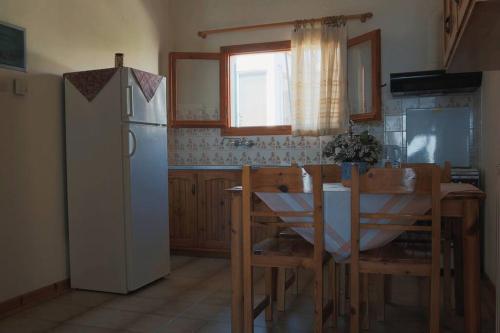 a kitchen with a white refrigerator and a table and chairs at Seaview selfcatering Studio Helen No 1 in Xiropigado