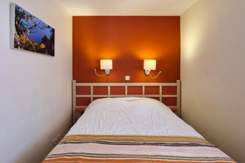 Ce lit se trouve dans un dortoir doté de 2 lumières sur le mur. dans l'établissement Sea view apartment 6 pers near the beaches in Agay, à Saint-Raphaël