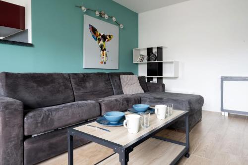 un salon avec un canapé noir et une table dans l'établissement Appartement Crista - Welkeys, à Saint-Denis