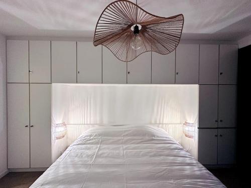 a bedroom with a large white bed with a fan at Terrasse des Dunes in Knokke-Heist
