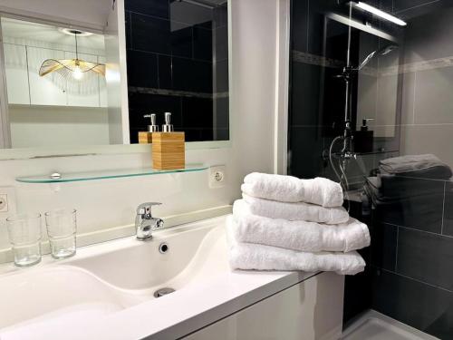 a bathroom with a sink and a tub with towels at Terrasse des Dunes in Knokke-Heist